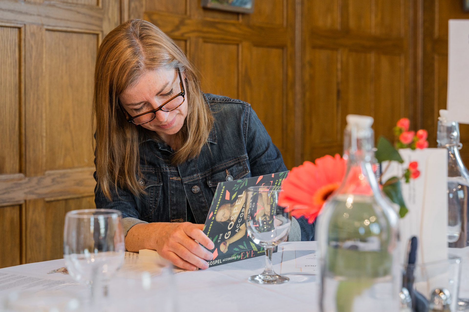 A woman autographs a book