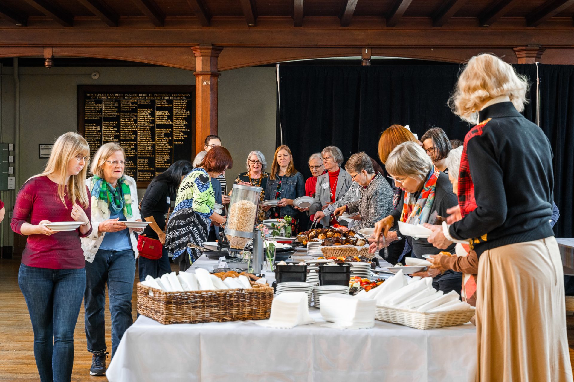 A group of women congregate around a buffet table for a catered breakfast