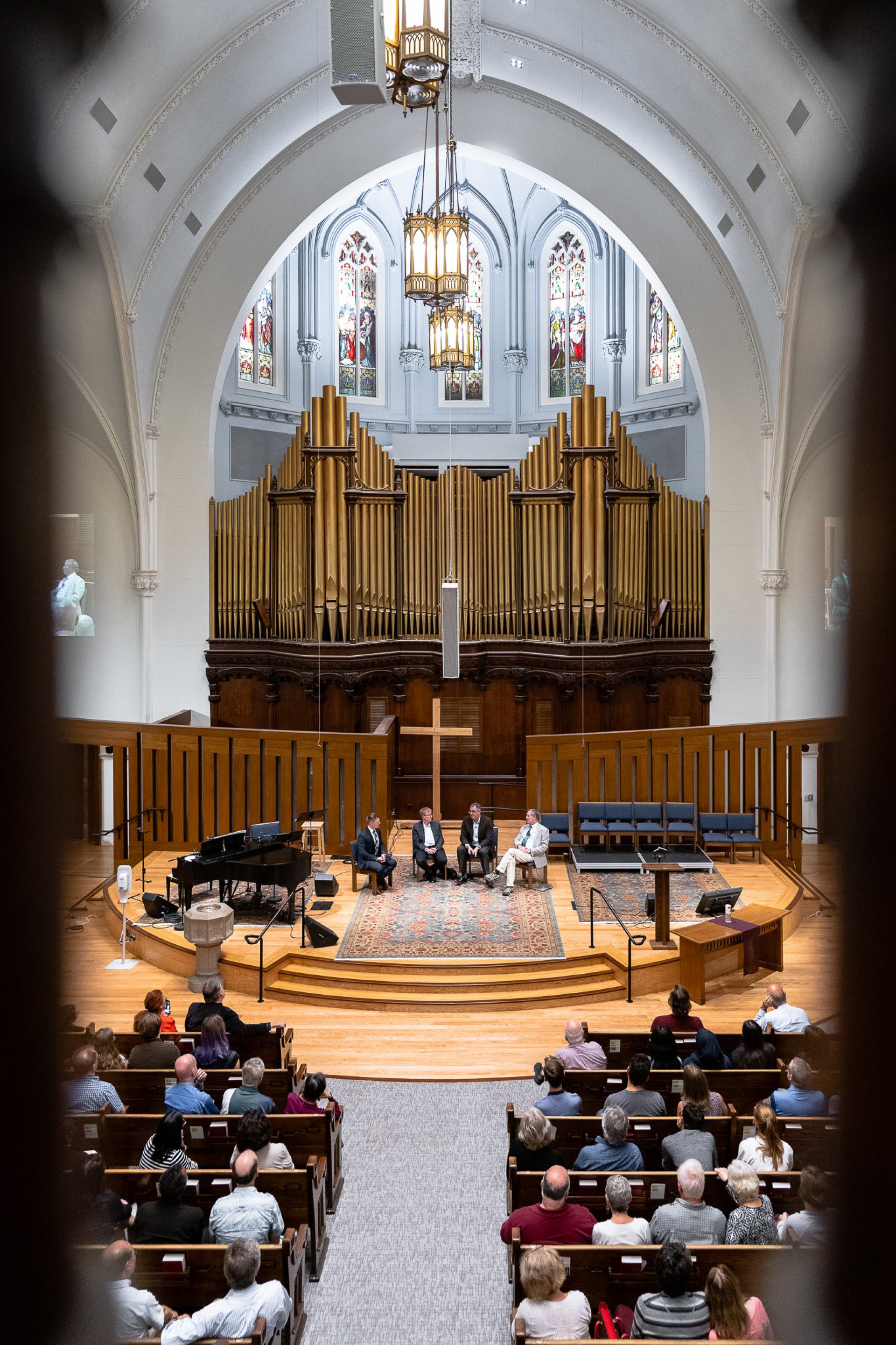 A group of men onstage at a church for a roundtable discussion